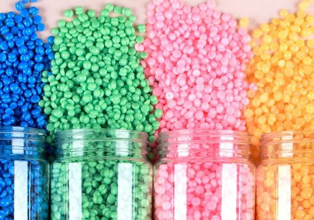Hard wax beans in five colourways spilling out of open bottles